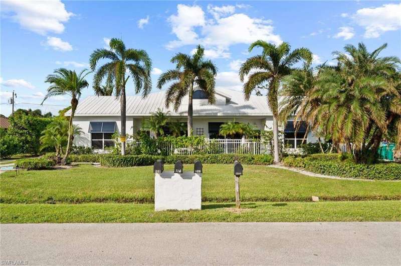 Ranch-style home with metal roof, fence, and a front lawn