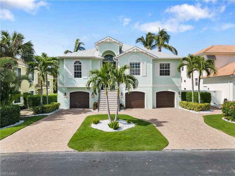 View of front of home with a front yard and a garage