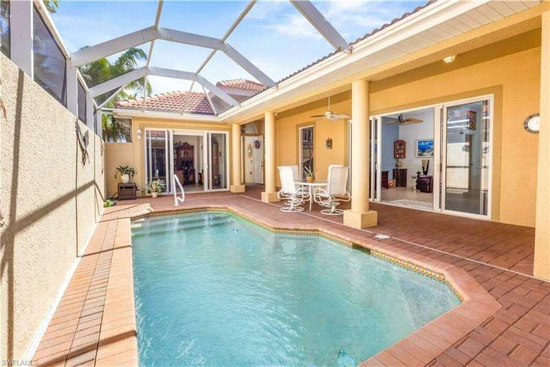 View of pool featuring a patio area, screen enclosure, and ceiling fan