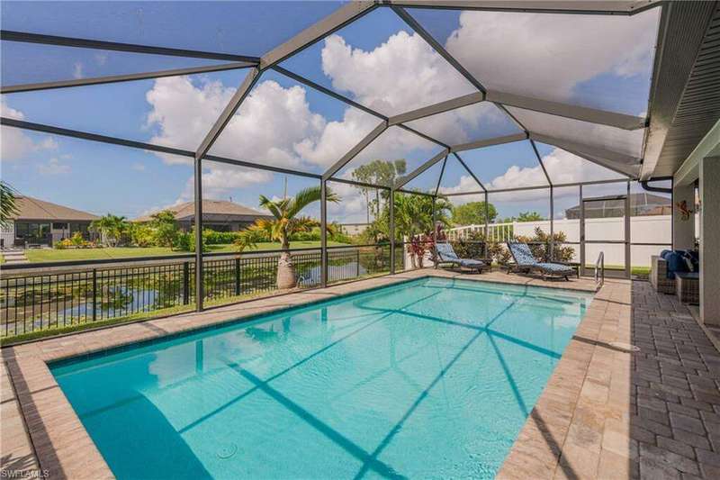 View of swimming pool & canal with screened lanai