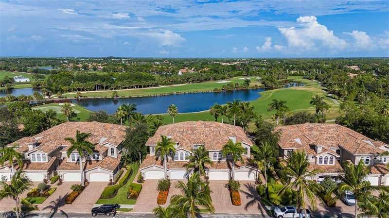 Aerial view of residential area featuring a golf club and a nearby body of water