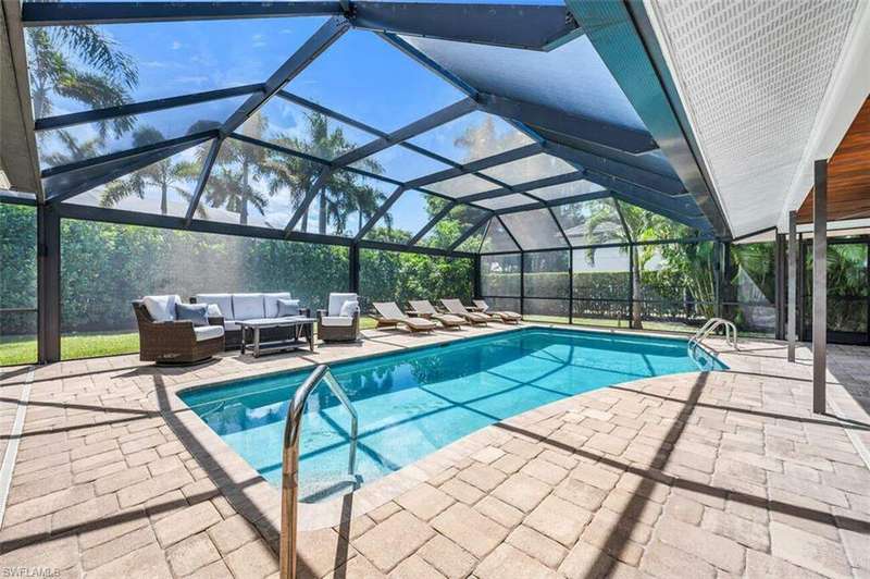 View of pool featuring a patio area, glass enclosure, and outdoor lounge area