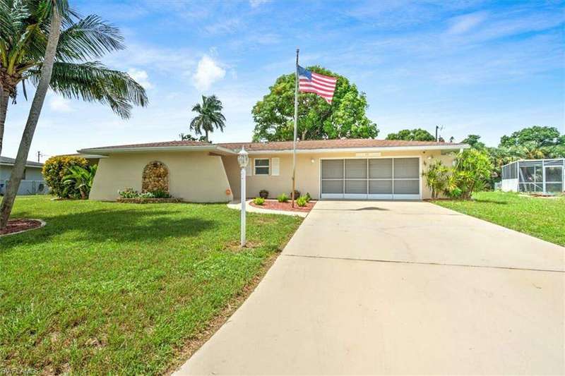 Ranch-style home with a garage and a front lawn