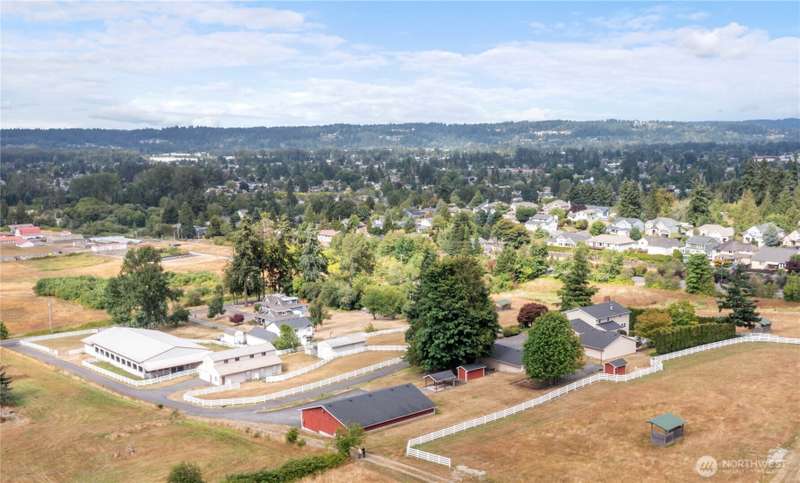 Overhead view of House & 2 garages on the right, red 10 car garage bottom middle, barn & equipment storage building towards the left & 60X120 covered arena on left with asphalt driveway. Top of picture on left is Tacoma & Edgewood @ top right. Valley in m