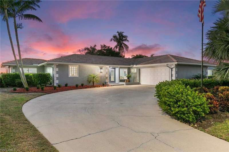 Ranch-style house featuring stucco siding, an attached garage, a tile roof, and driveway
