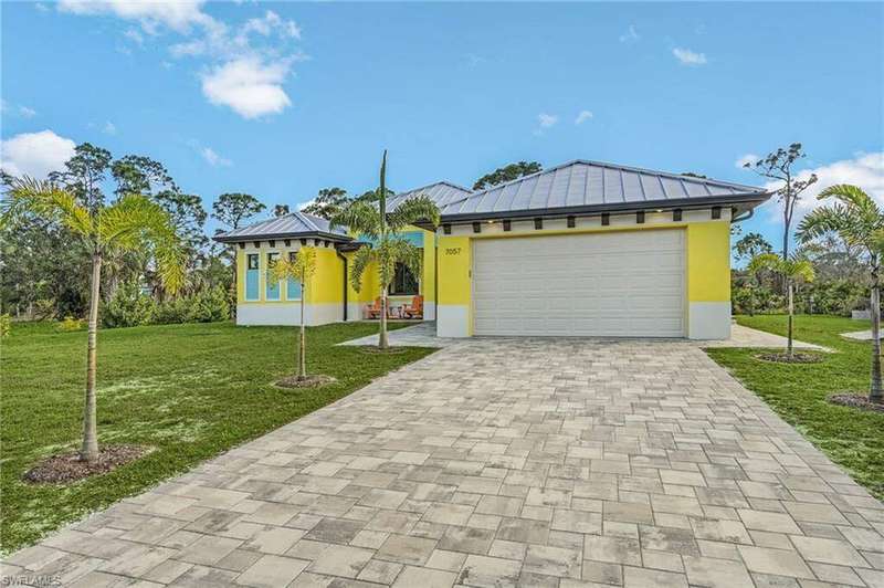 View of front of house with a garage and a front lawn