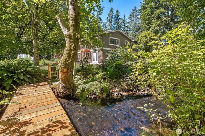 Country-style Pacific Northwest rambler with gorgeous Redwood Siding includes a walkout basement with full apartment on 1.1 Acres -- And who doesn't love a welcoming covered porch?