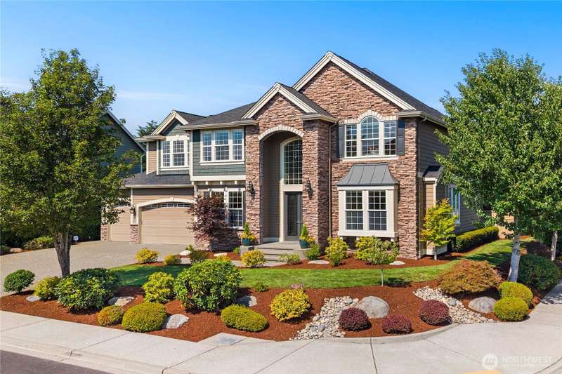 Beautiful stone-accented façade with manicured landscaping and a welcoming presence on a private corner lot.