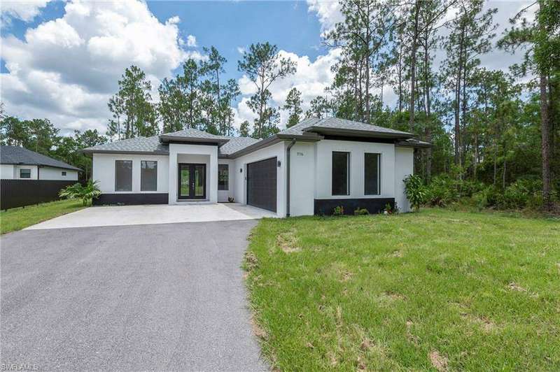 View of front of property with a garage and a front yard