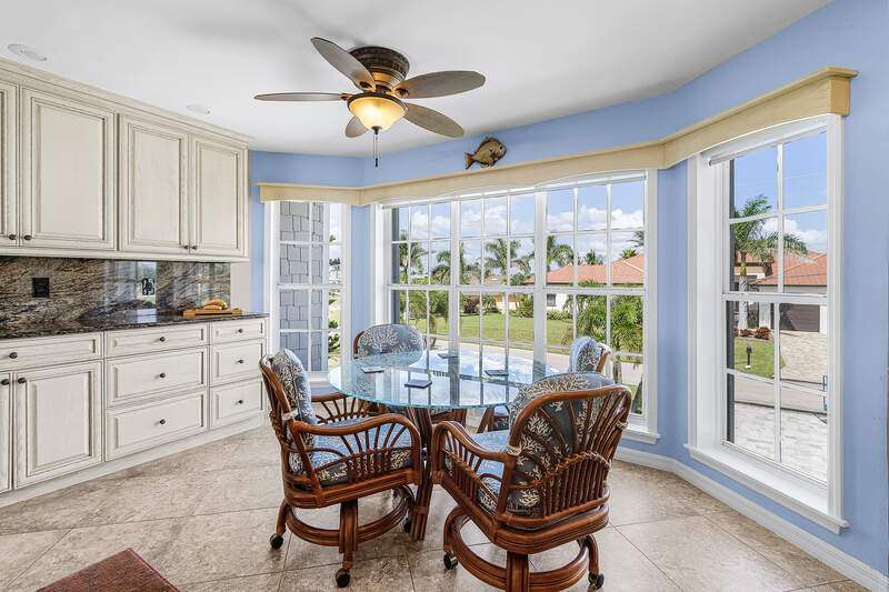View of front of house with a front lawn, decorative driveway, a metal roof, and a garage