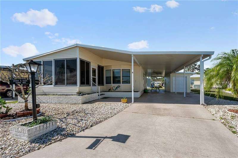 Rear view of house with a sunroom and a carport
