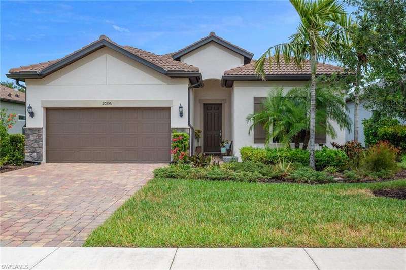 Mediterranean / spanish home with stucco siding, driveway, an attached garage, a front lawn, and a tiled roof
